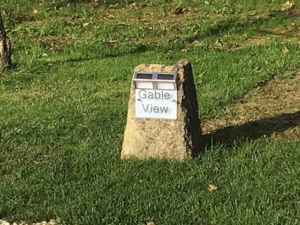 A sign labeled "Gable View" on a concrete post in a grassy area. - Amazing views in luxury cottage (Cheltenham)