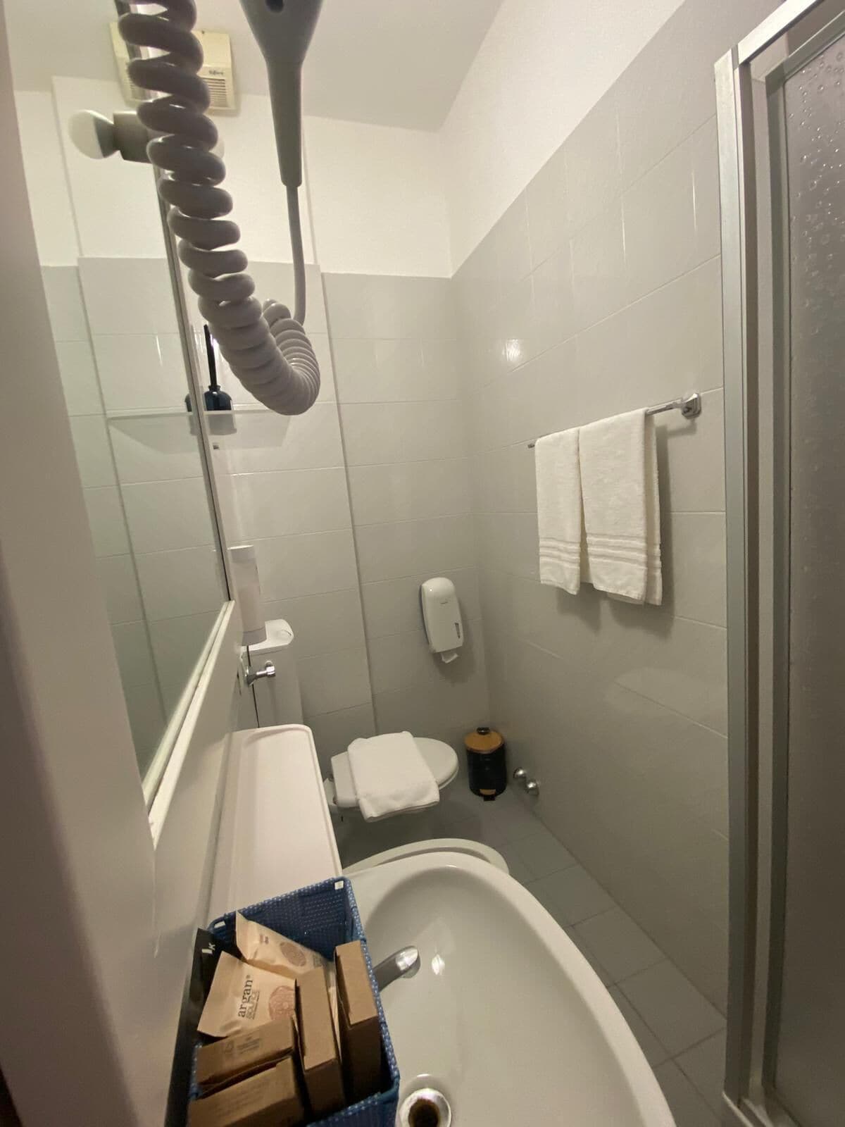 Een badkamer met een bad, toilet, handdroger en spiegel.