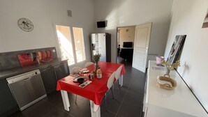 A compact kitchen with a dining table, a refrigerator, and a clock on the wall. - T3 - First floor - With swimming pool - Rated 5 * furnished for tourism (Piana)