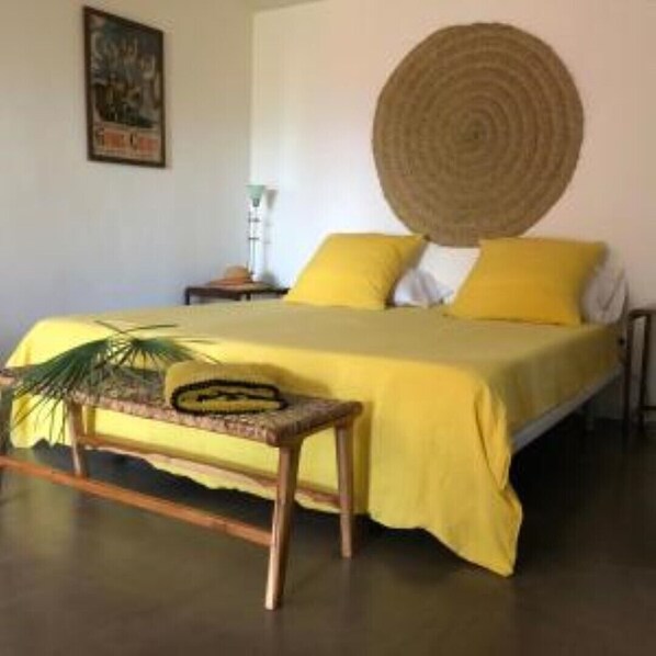 Cozy retreat with a comfortable bed, woven mat, and plush bench.