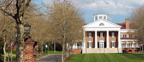A large, historic building with a symmetrical facade, columns, and a central pediment.