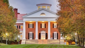 A historic building with a central entrance, flanked by brick columns, and a cupola on top. - Kimpton The Forum Hotel by IHG (Charlottesville)