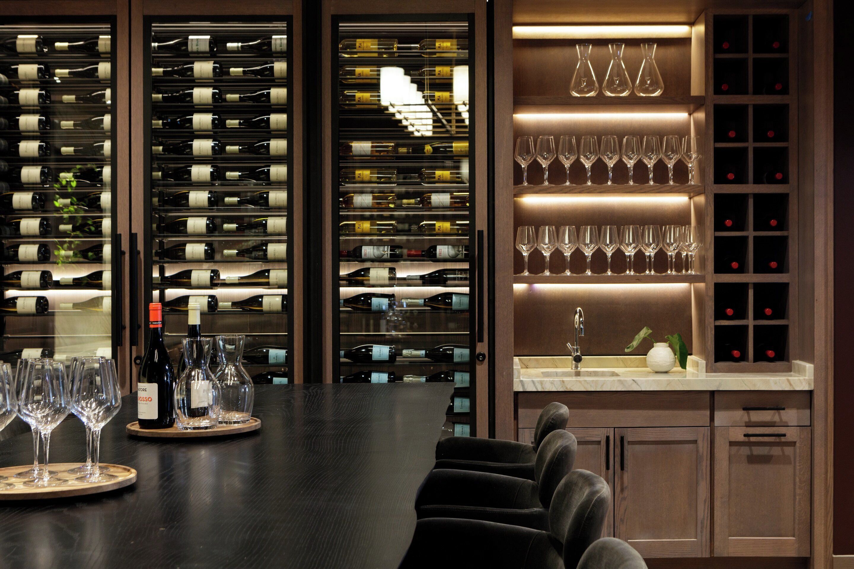 A bar area with wine racks, glasses, and seating.