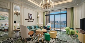 A spacious hotel room with a large window offering a city view, a green sofa, a round coffee table, and a television. - Crowne Plaza Dongying by IHG (Dongying)