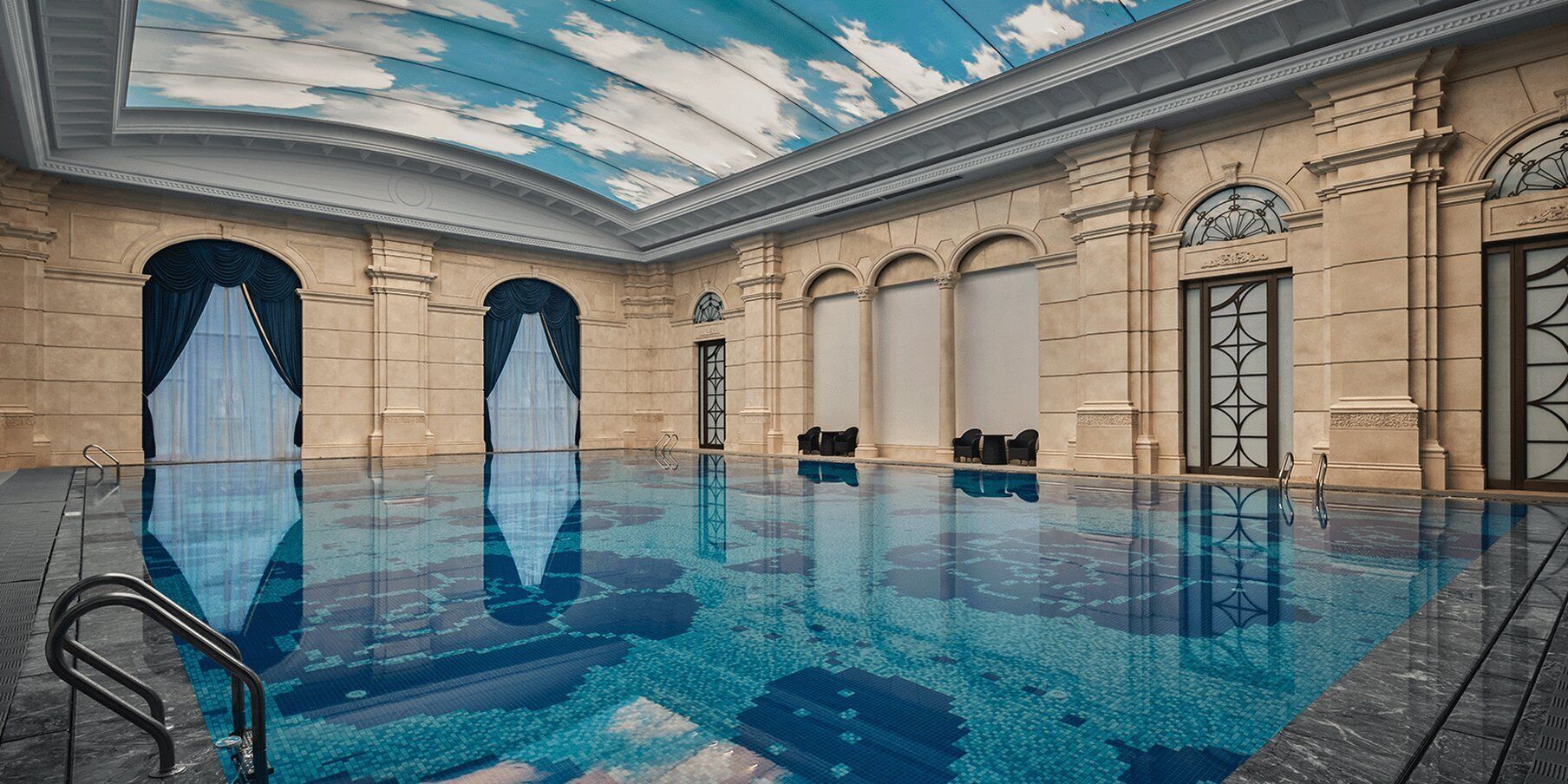 Una piscina interior con superficie de agua azul cristalina, rodeada de arquitectura clásica con columnas y arcos.
