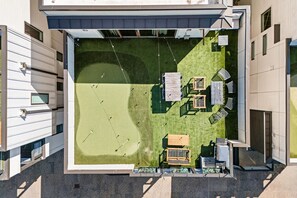 Vue aérienne d’une cour comprenant une pelouse, un espace détente et une petite piscine.