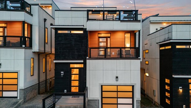 Un immeuble résidentiel moderne à plusieurs étages, doté d’un toit plat, de grandes fenêtres et d’un balcon.