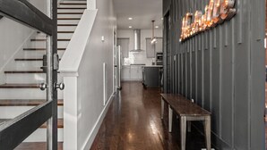 Un intérieur moderne avec un escalier, un banc et un coin cuisine.
