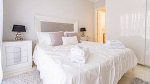 A modern bedroom with a large bed, two bedside tables, a nightstand, and a wardrobe. - Townhouse in Palm-Mar  (Arona)