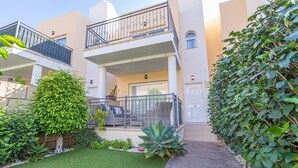 A modern building with a balcony, a door, and a well-maintained garden. - Townhouse in Palm-Mar  (Arona)