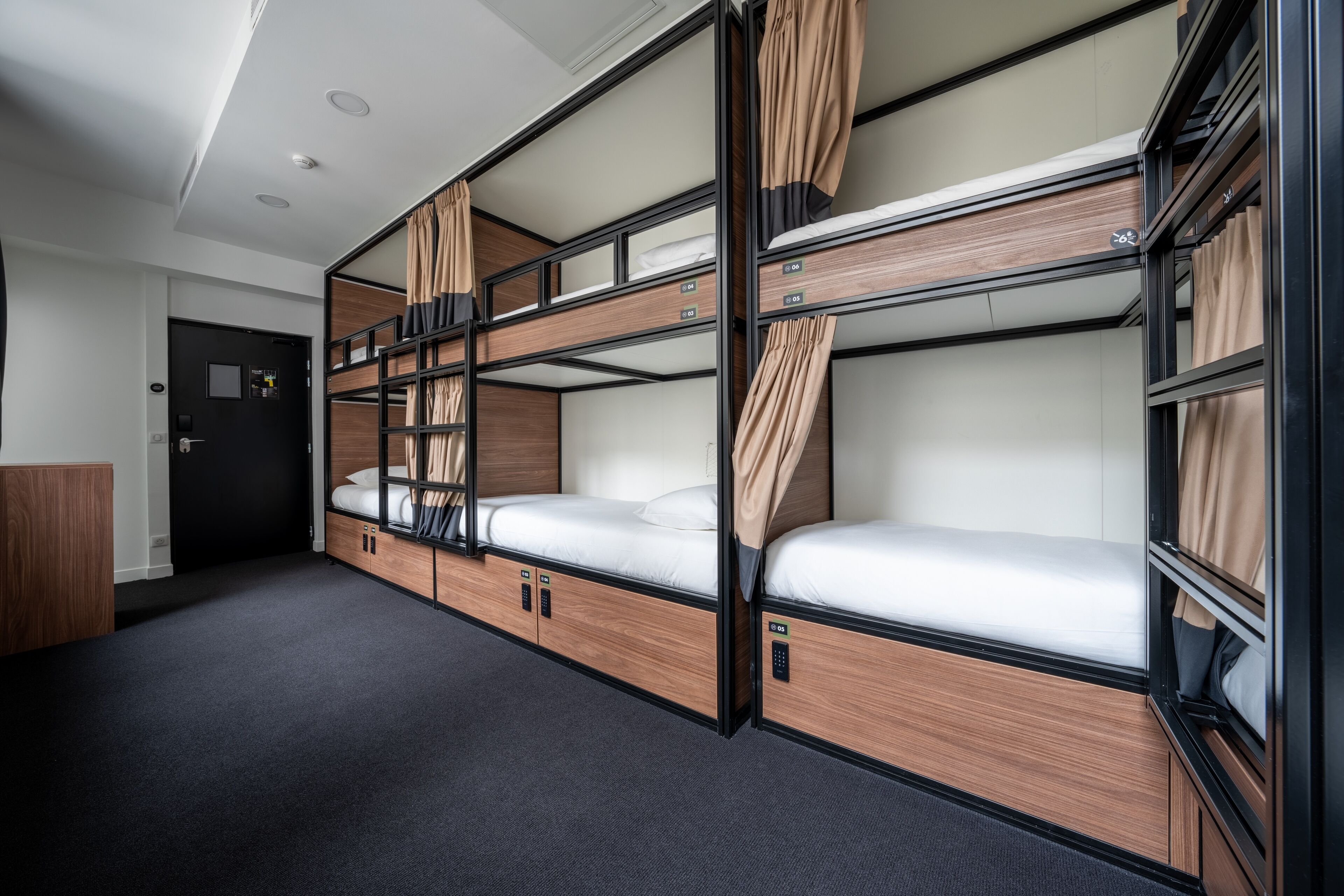 Una habitación de hotel pequeña con literas, un escritorio y un armario.