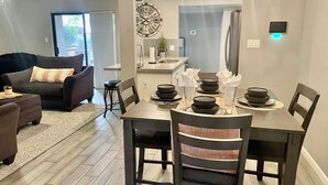 A modern dining area with a wooden table set for four, surrounded by dark wooden chairs. - AZ Peaceful Retreat in Scottsdale (Scottsdale)