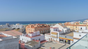 Une ville côtière avec des bâtiments, une rue bien visible et une vue dégagée sur la mer.