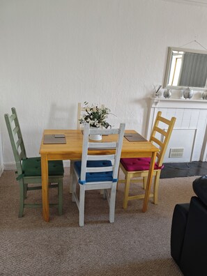 A dining area with a wooden table and four chairs, a small potted plant, and a white cabinet with decorative items. - Kirkcaldy, Fife • Lovely 2 Bedroom Flat • Sea View (Kirkcaldy)