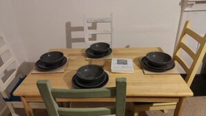 A wooden dining table with four black bowls and a menu. - Kirkcaldy, Fife • Lovely 2 Bedroom Flat • Sea View (Kirkcaldy)