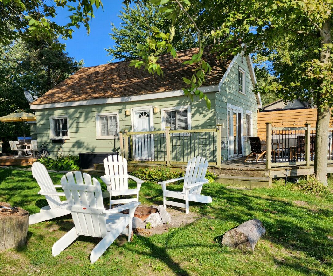 A house with a deck, outdoor seating, and a fenced yard.