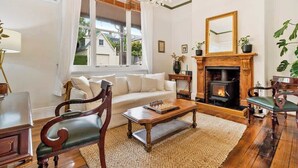 A living room with a fireplace, a sofa, a coffee table, and a chandelier.