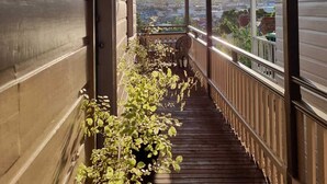 A covered balcony with a view of the cityscape.
