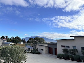 A residential area with modern houses, a clear sky, and mountains in the background.