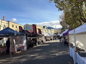 A street market with various stalls, including a coffee stand and a stall with dog-related items.
