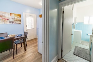 A dining area with a table, chairs, and a refrigerator. - Mathilda Street Trio - Stylish 2BR Apt (Pittsburgh)