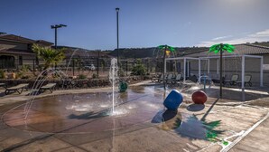 A water feature with multiple jets, surrounded by lounge chairs and a covered seating area. - Sand, Sun & Fun! (Washington)