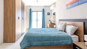 Een slaapkamer met een bed, een houten garderobe en een nachtkastje.