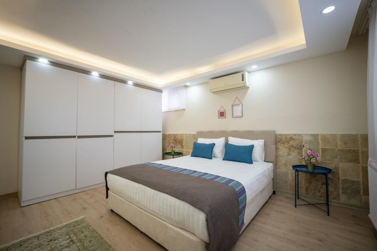 Un dormitorio con cama, mesitas de noche, aire acondicionado y armario.