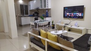 Ein modernes Wohnzimmer mit einer Couch, einem Couchtisch und einem an der Wand befestigten Fernseher.