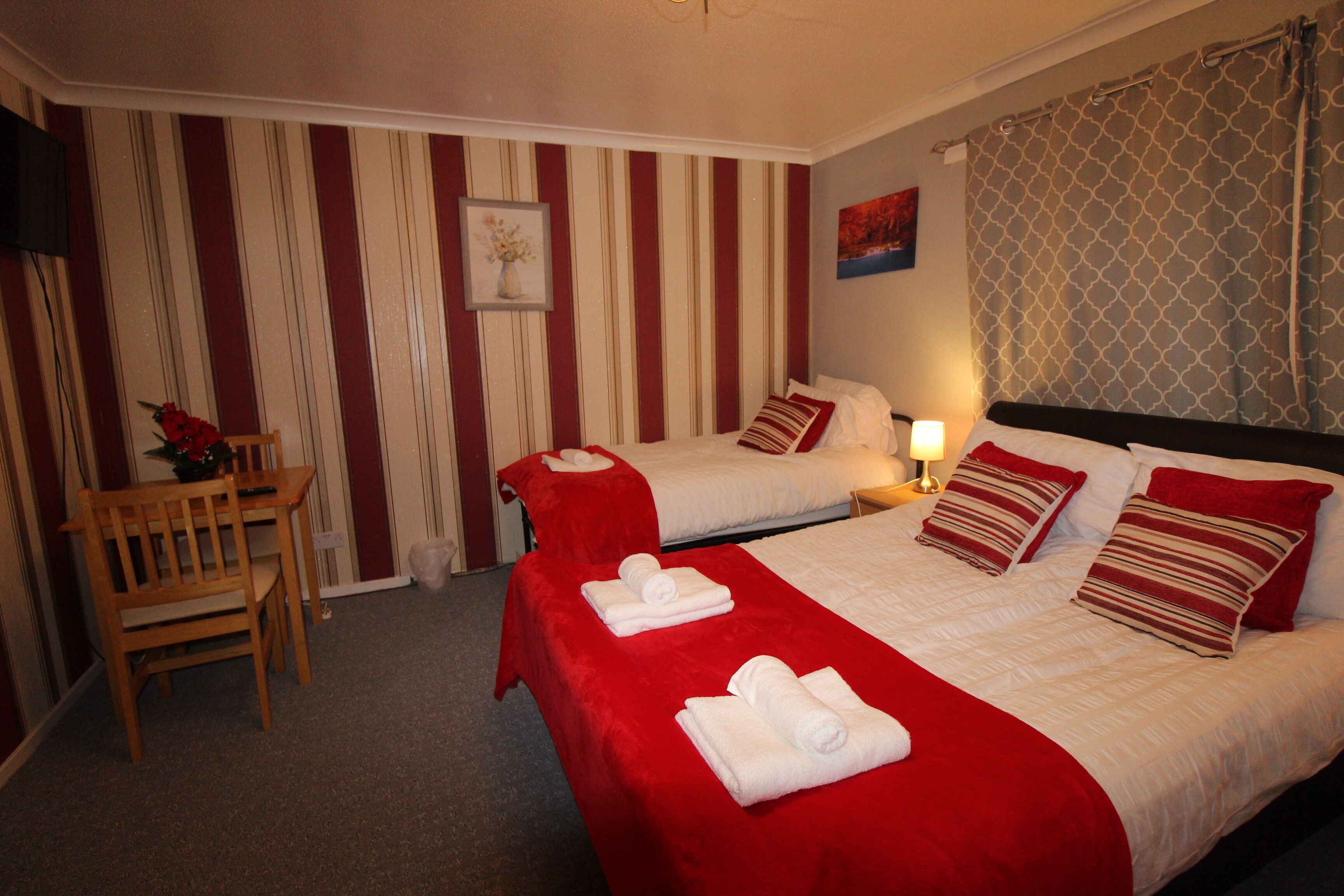 Ein Hotelzimmer mit zwei Betten, einem Schreibtisch und einem Stuhl.