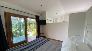 A bedroom with a large bed, a window with curtains, a flat-screen TV mounted on the wall, and a ceiling with recessed lighting. - Chena Magica (Calera de Tango)