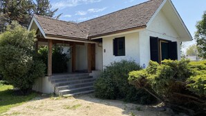 A single-story house with a sloped roof, a covered porch, and a front entrance with steps. - Chena Magica (Calera de Tango)