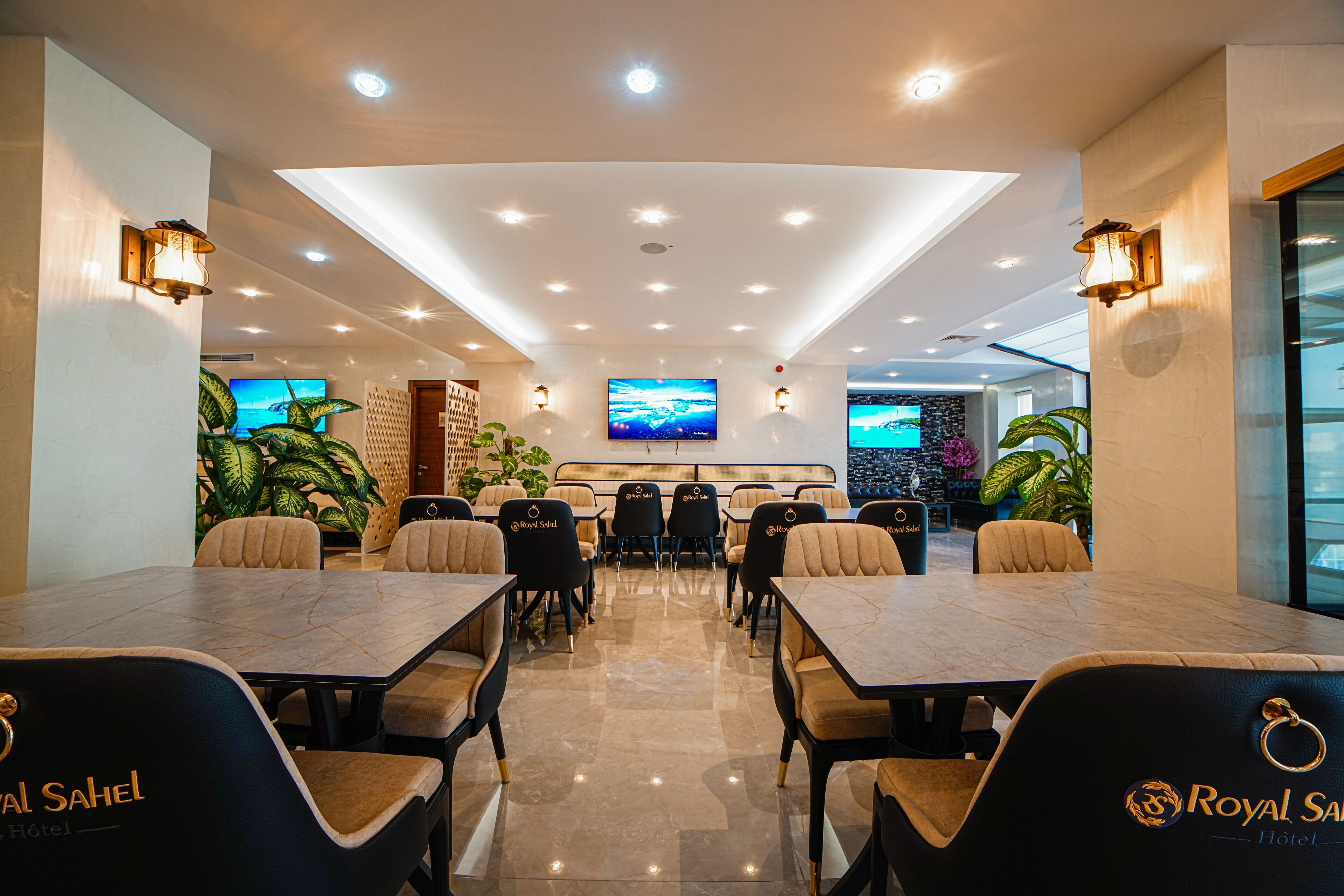 A conference room with a long table, multiple chairs, and a large screen.