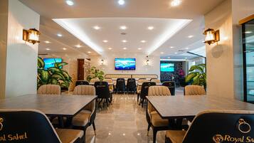 A conference room with a long table, multiple chairs, and a large screen.