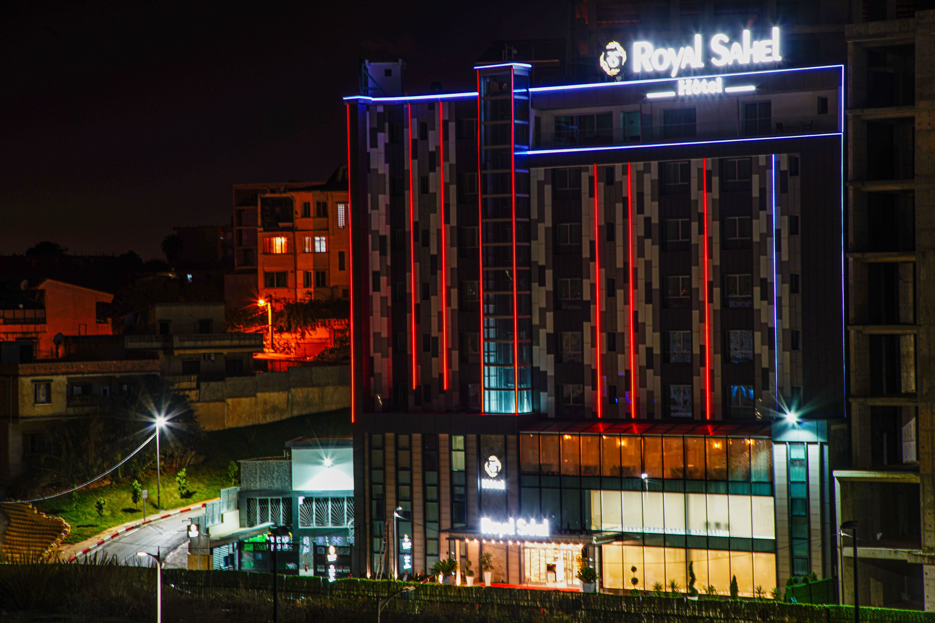 Un hôtel doté d’une façade moderne, d’une enseigne lumineuse et d’une entrée bien visible.