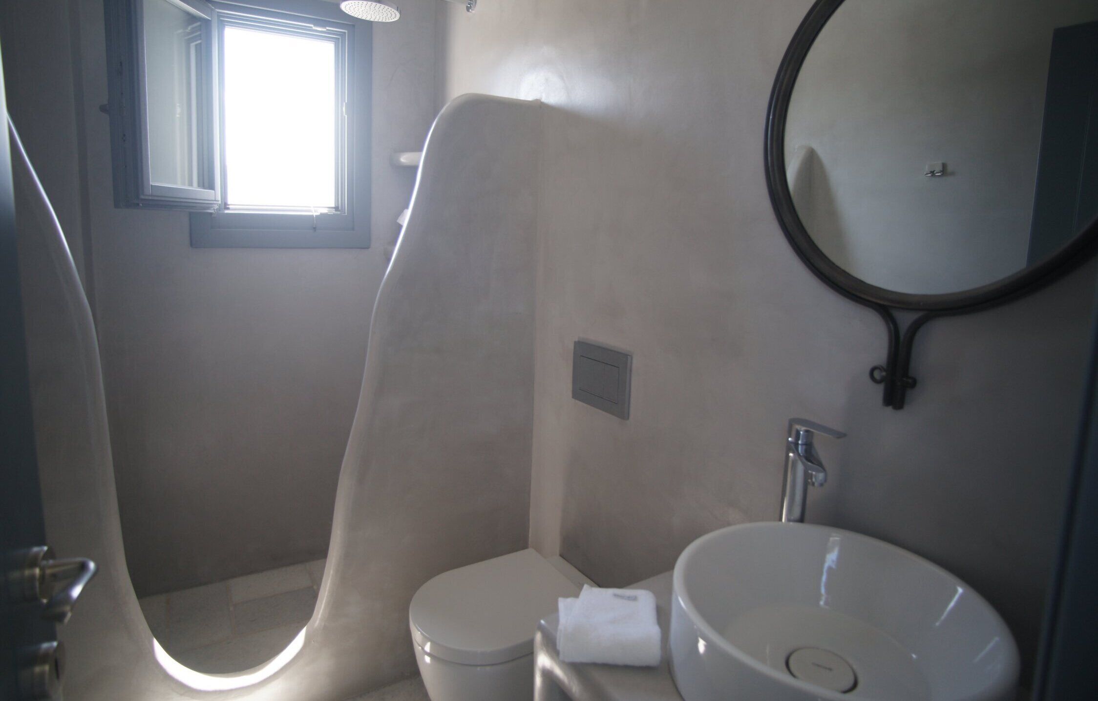 A bathroom with a toilet, a sink, and a shower.