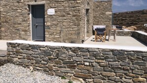 A stone building with a door and a sign that reads "Ametzola." - Krotiri View of Paros (Paros)