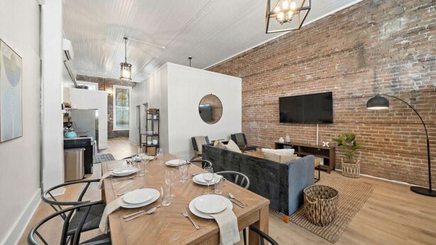 A modern living space with a dining area, kitchen, and seating area.