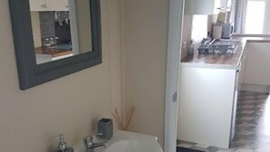 A bathroom with a white sink, a mirror, and a cabinet. - Lovely 2-bed Chalet at Robinhood Retreat Free Park (Newark)