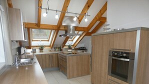 Een moderne keuken met houten kastjes, een roestvrijstalen oven en een dakraam.