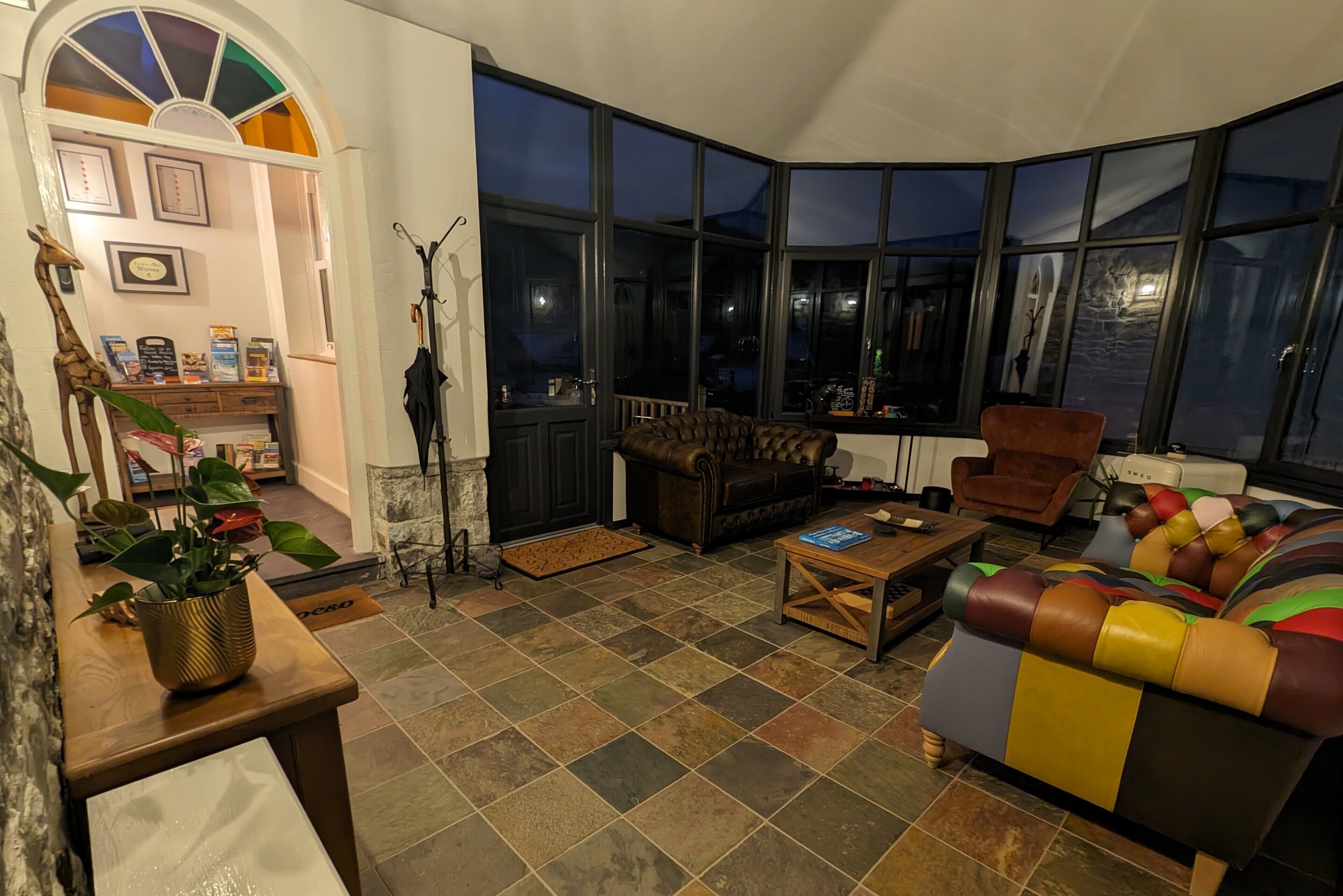 A cozy living room with a fireplace, a large window, and a comfortable seating area.