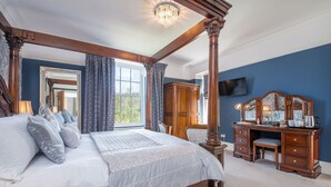 A four-poster bed with a canopy, a wooden desk with drawers, a television mounted on the wall, and a large mirror. - Llys Aeron Guest House (Aberaeron)