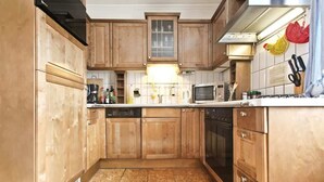 A kitchen with wooden cabinets, a microwave, a stove, and a dishwasher.