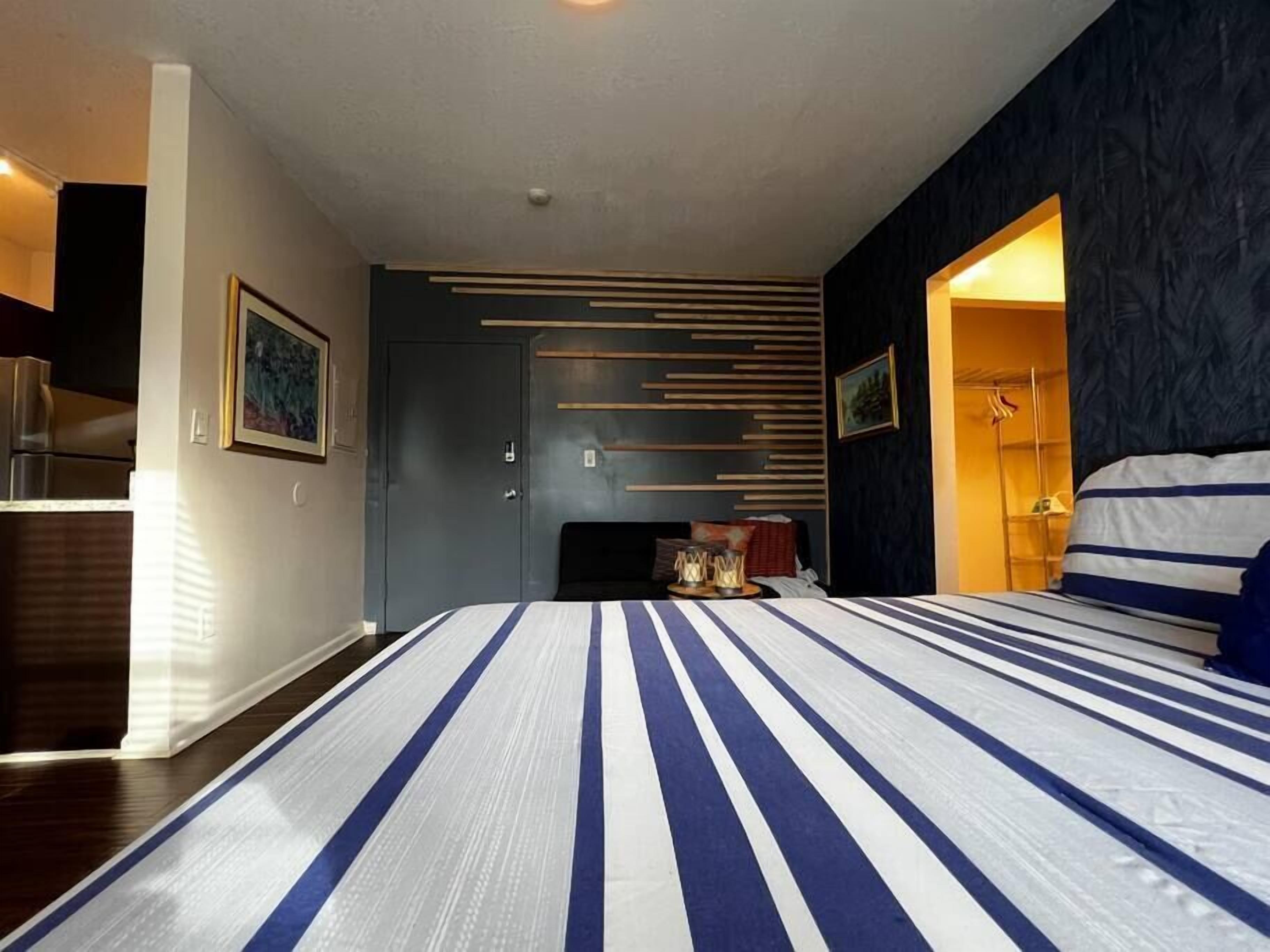 Un dormitorio moderno con una cama grande, una pared de acento oscura y un armario empotrado.