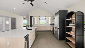 Una cucina moderna con isola centrale, elettrodomestici integrati e vista sull'esterno.