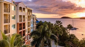 A multi-story hotel with balconies overlooking a body of water and palm trees. - FULL RESORT ACCESS! Marriott Two Bedroom Suites with full kitchen (St Thomas)