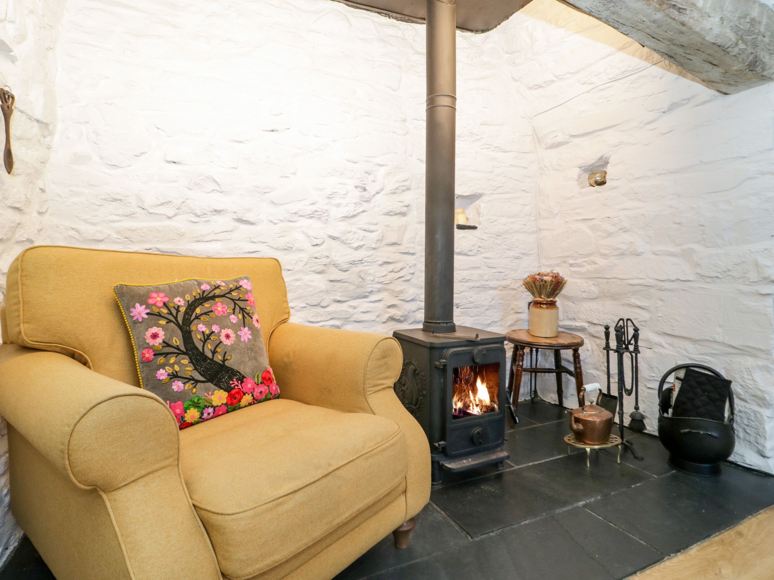 A cozy room with a sofa and a fireplace.