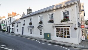 A white building with a sign reading "TAN LAN BAKERY" on the ground floor. - Sea Chest (Conwy)