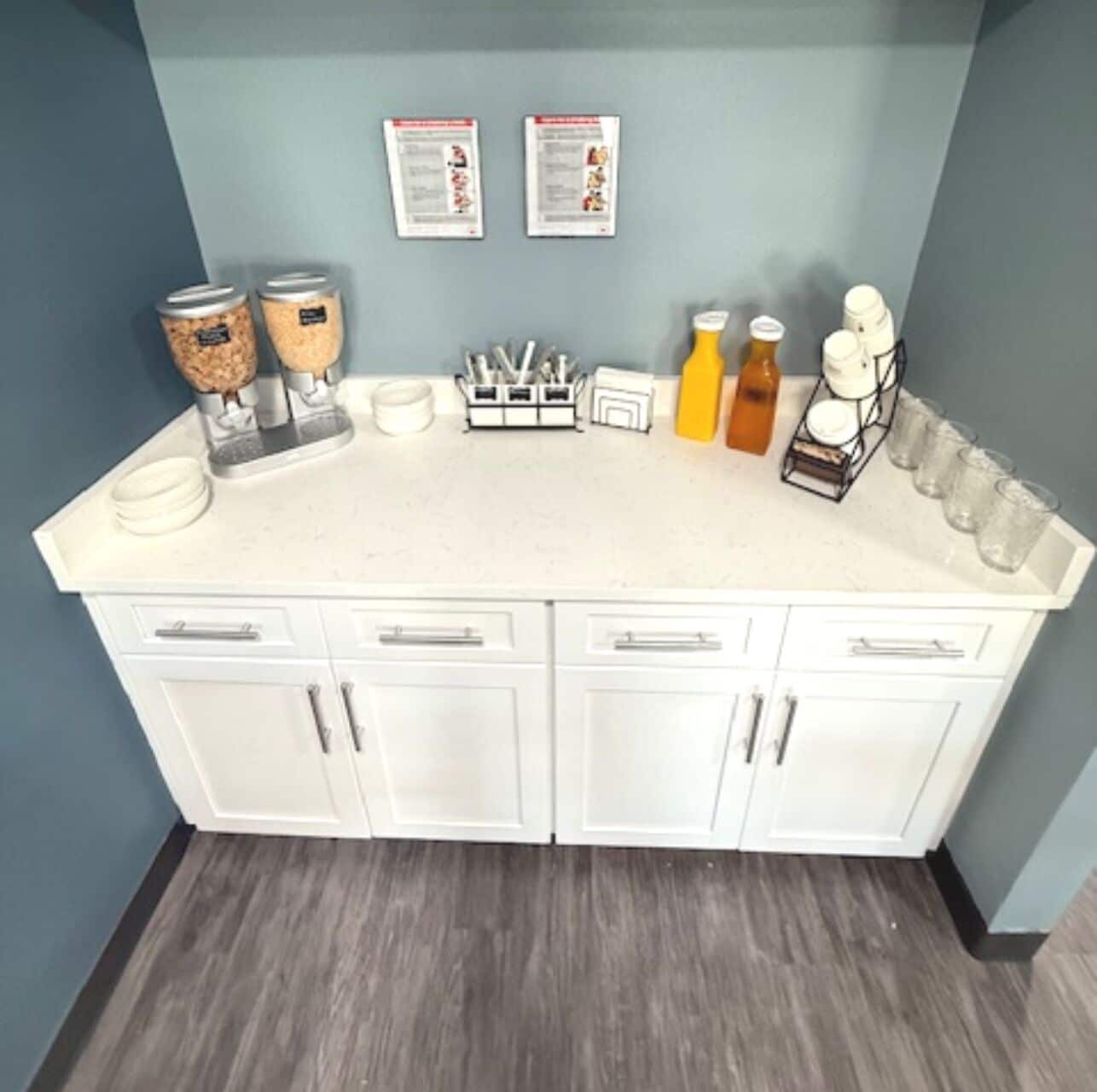 A kitchen with white cabinets, a countertop, and various kitchen items like jars, a coffee maker, and utensils.