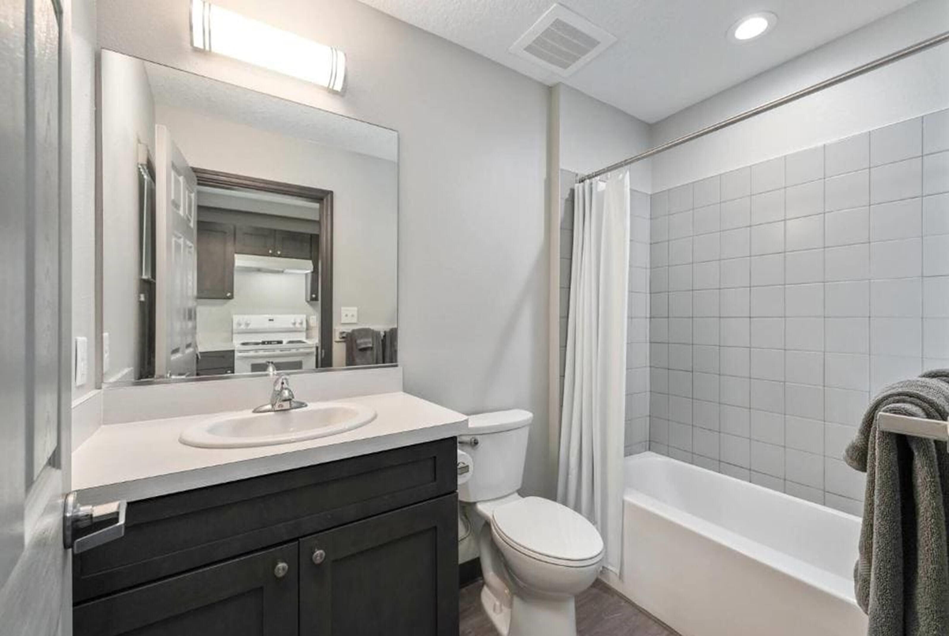 Un baño moderno con lavamanos, inodoro y bañera.